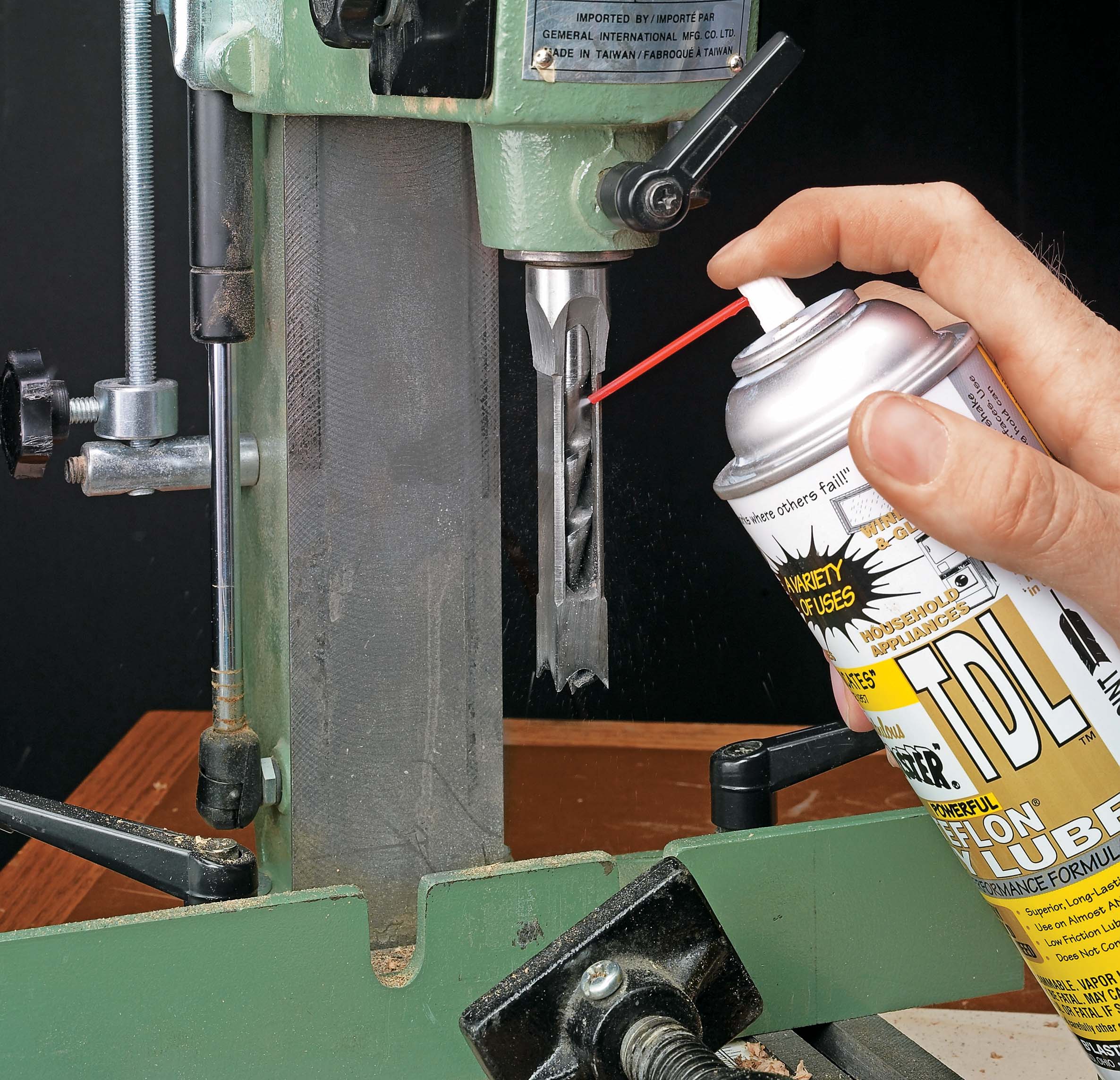 Spraying hollow chisel bit with dry lube