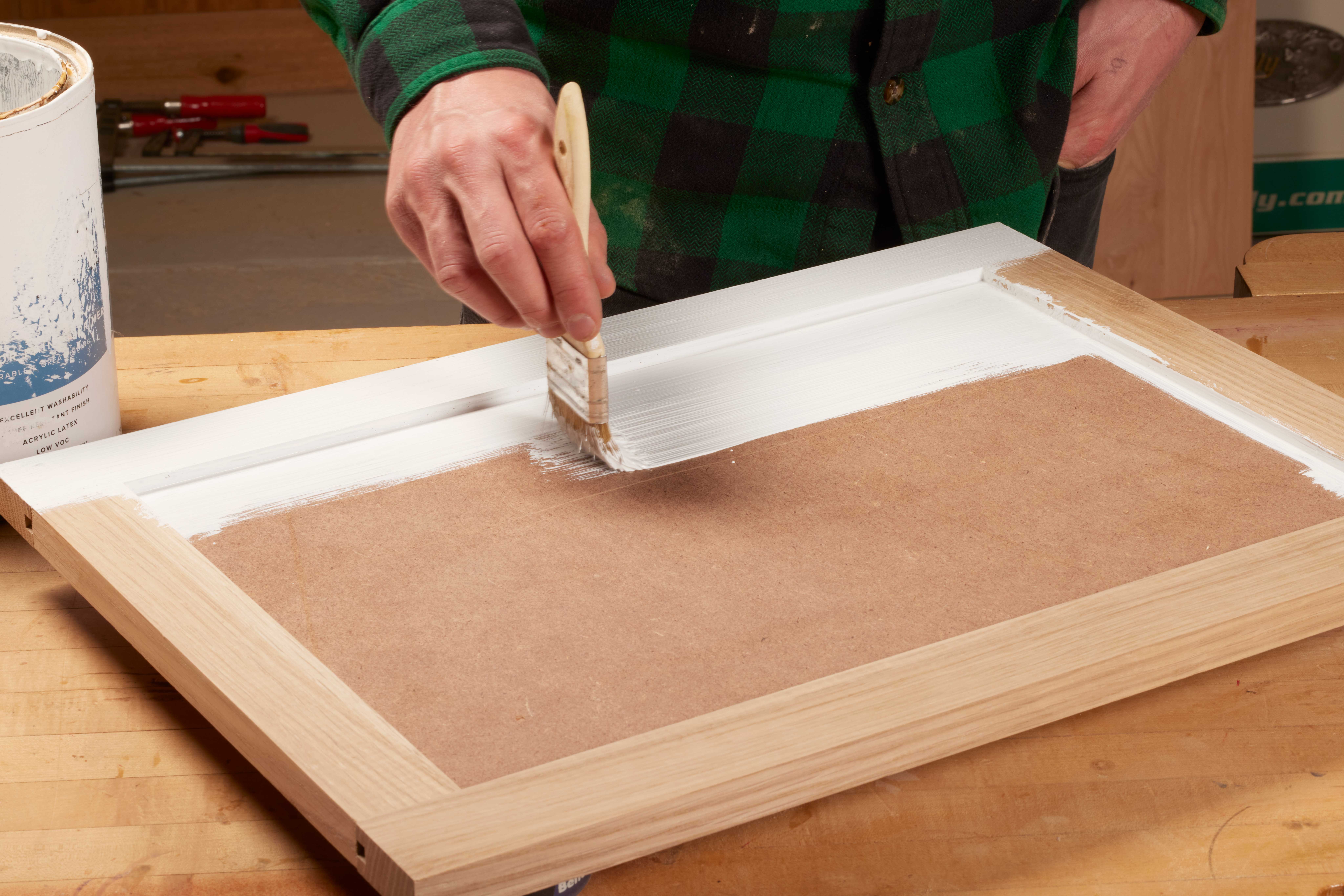Image of painting primer on wood to cover up surface level imperfections