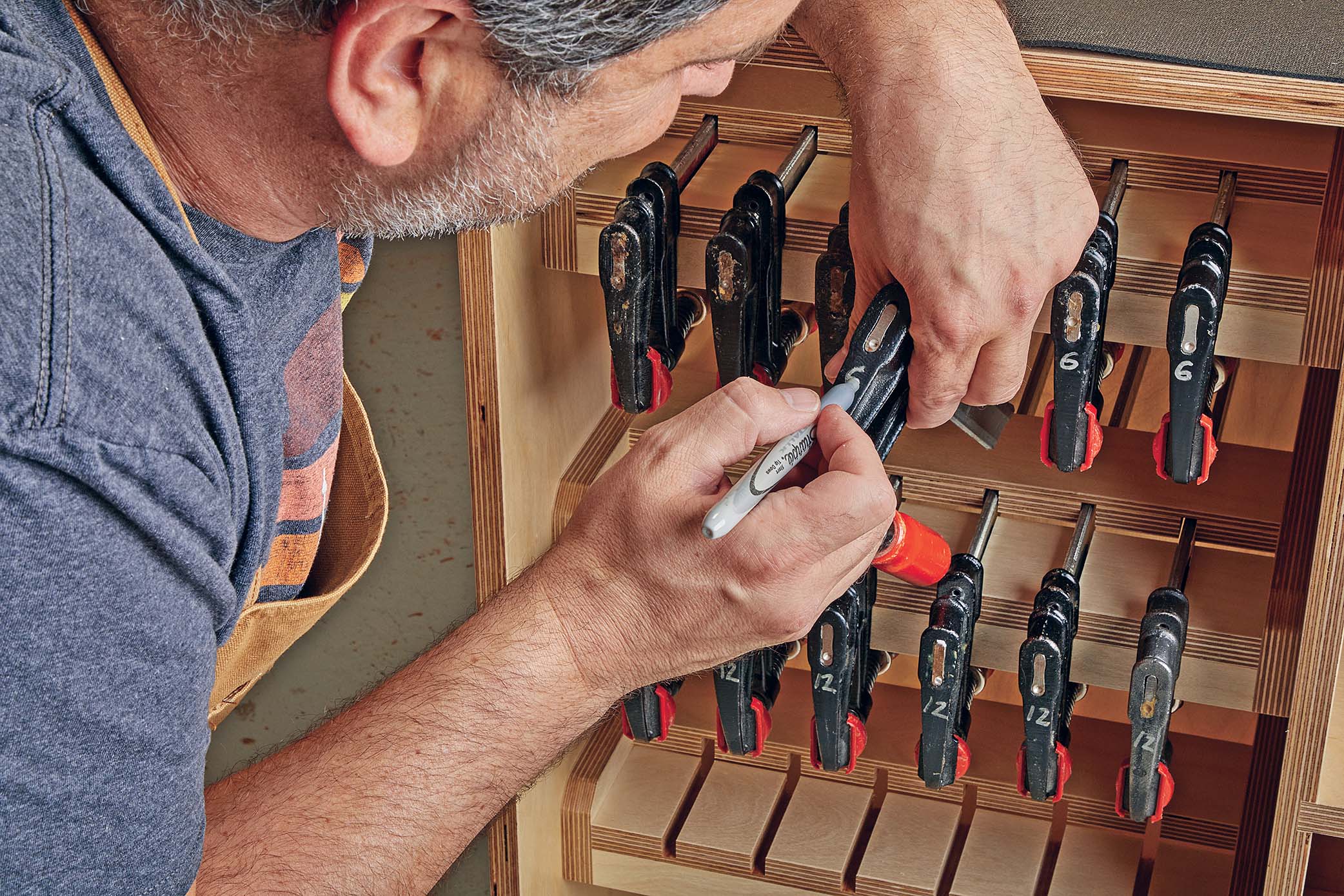 labeling bar clamps head with their sizes using a silver sharpie