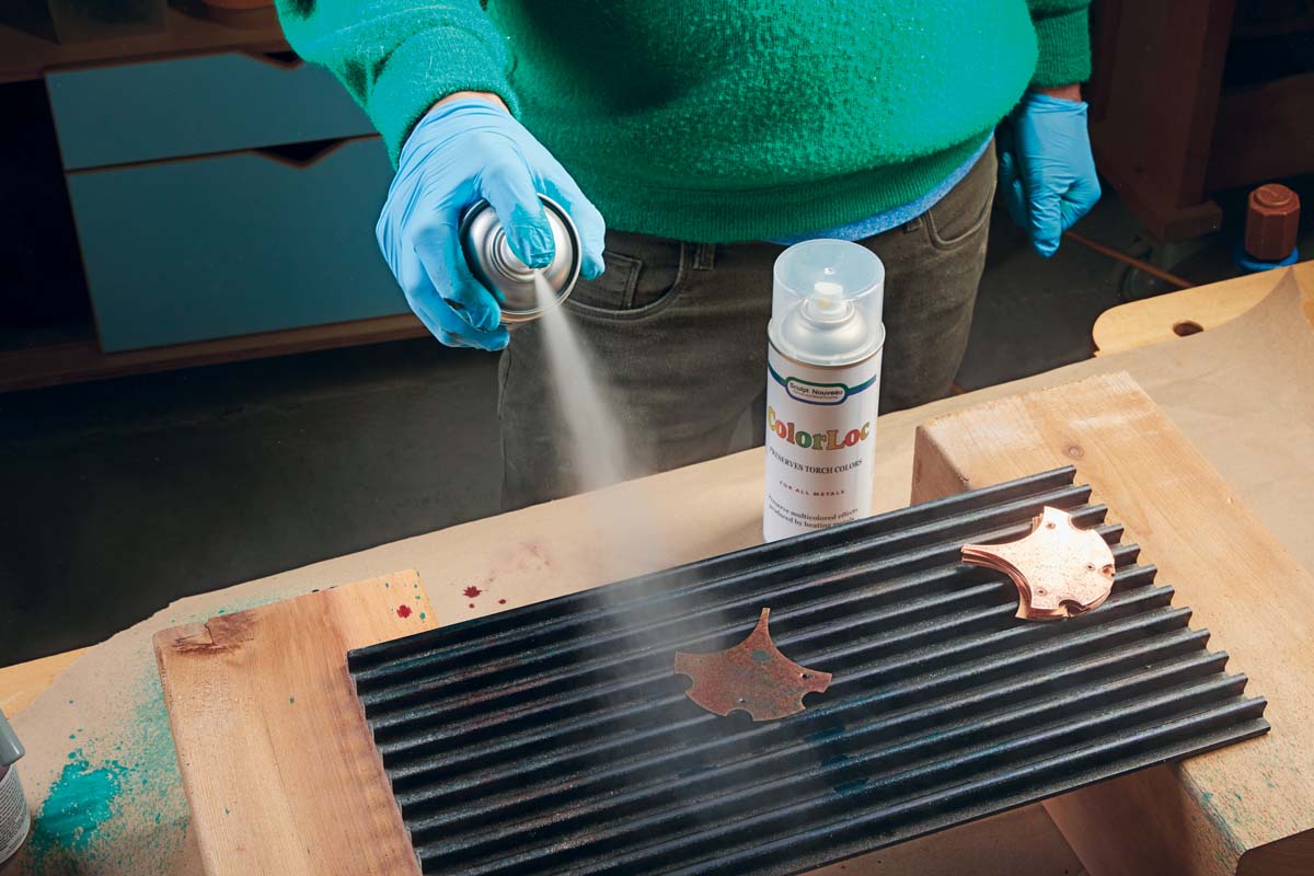 spraying top coat of Ever Clear on copper ginkgo leaf