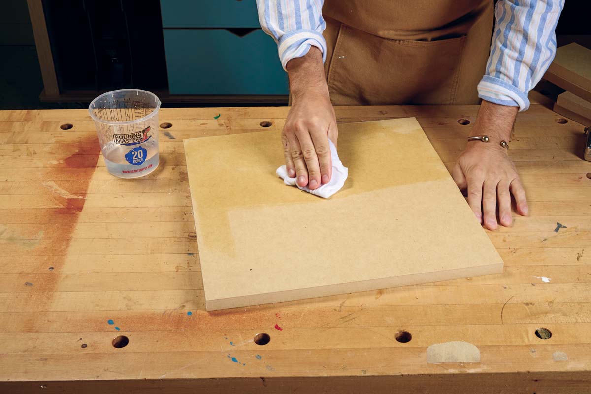 using white lint free cloth to wipe down mdf board with water