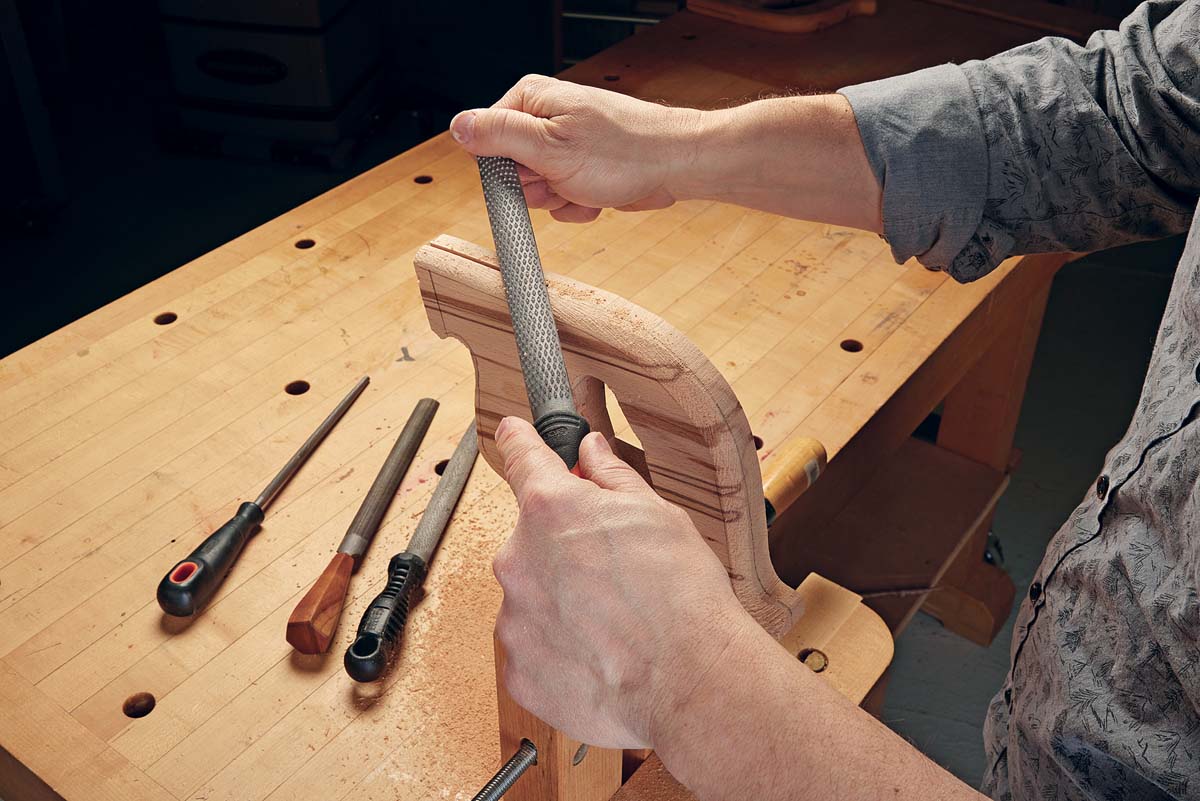 coarse rasp being used on wooden saw handle