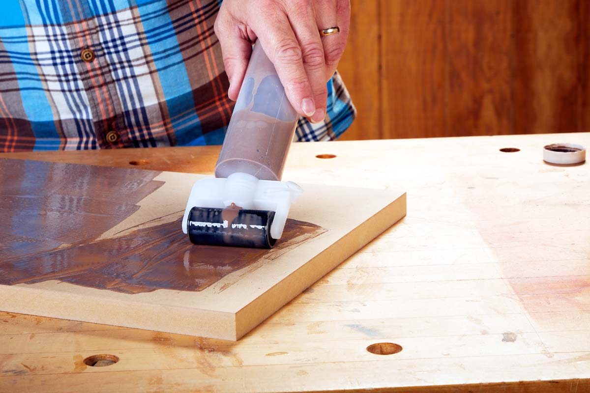 bottle with attached roller spreader for veneer