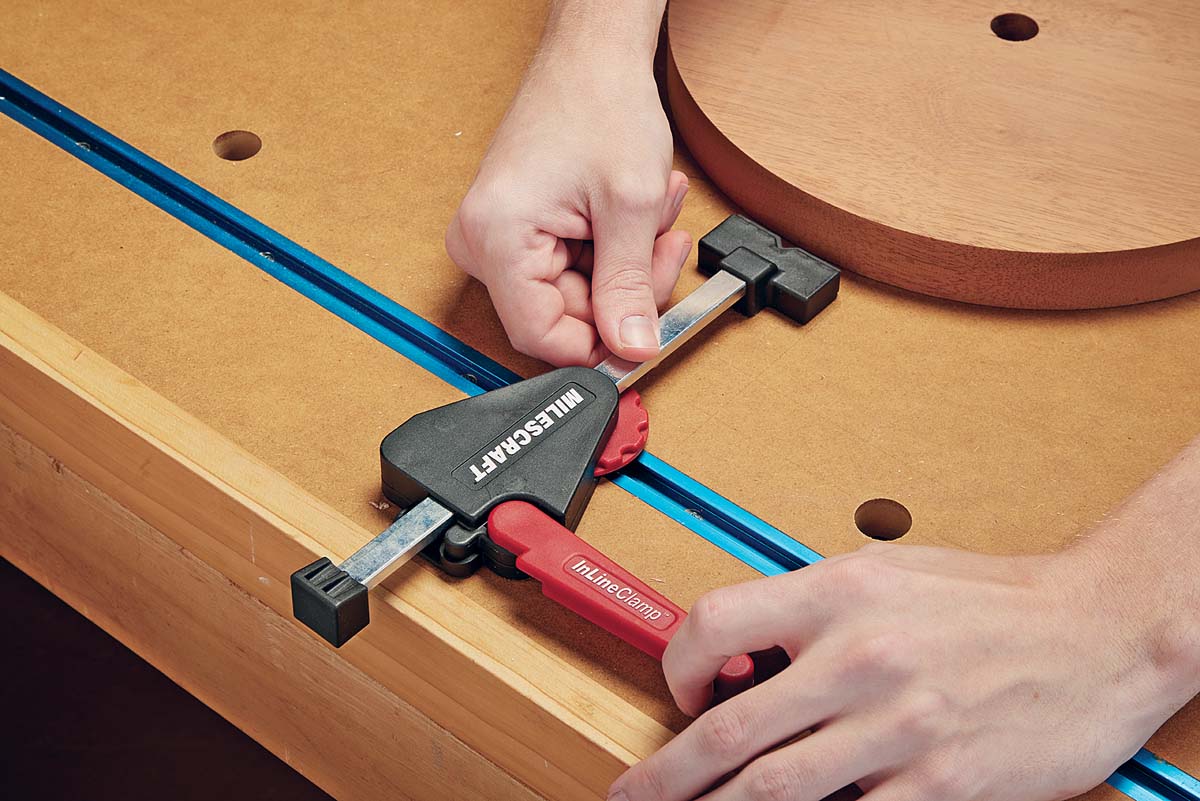 Milescraft Inline clamps being used to secure T-track and lock the workpiece in place 