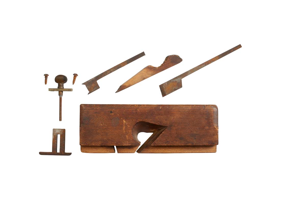 image of disassembled dado plane with parts depth stop, adjustment knob, nicker blade, wood body, skewed blade