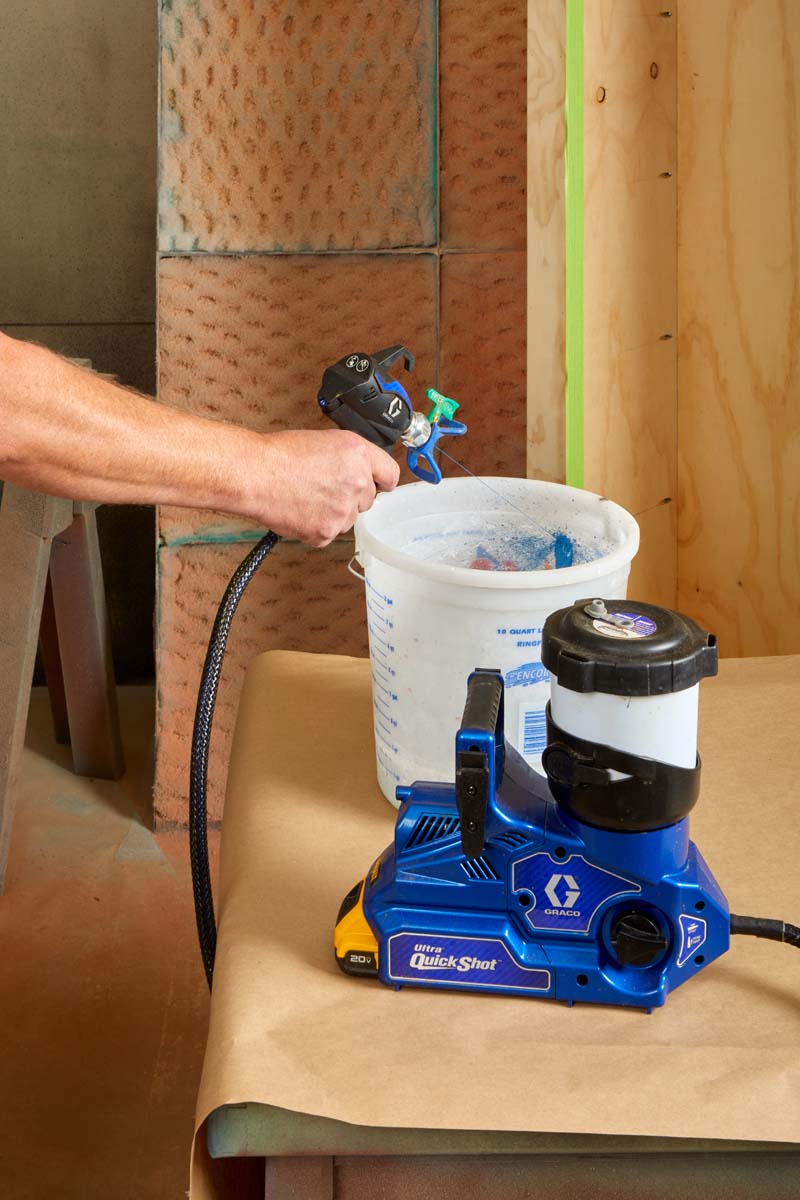 Graco ultra quick shot sprayer praying blue paint into bucket