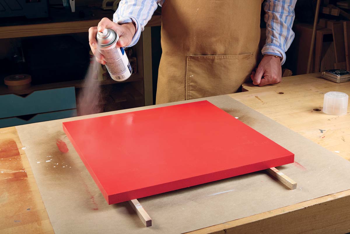 spraying clear varnish on the red high gloss paint