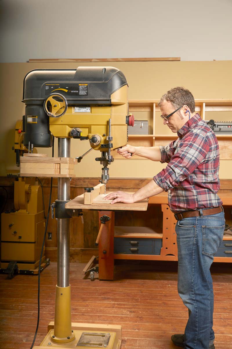 image show man using a drill press at his own elbow height
