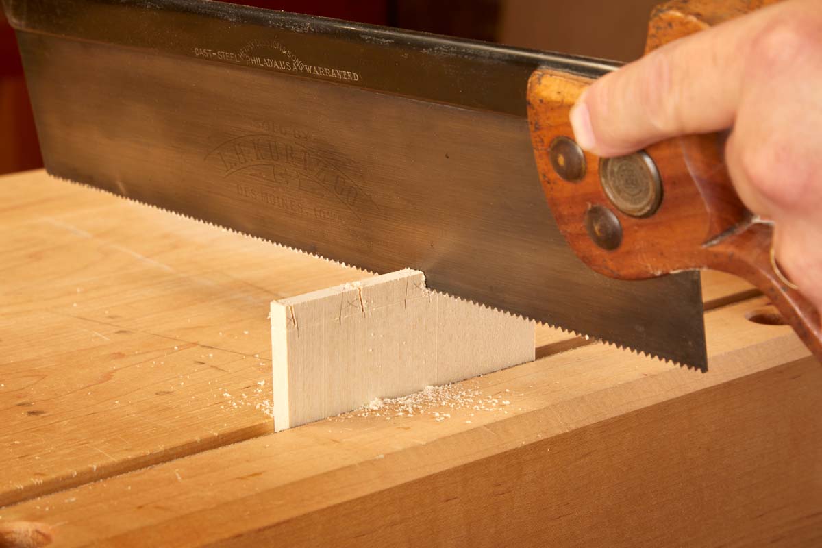 using hand saw to cut dovetails vertically up and down