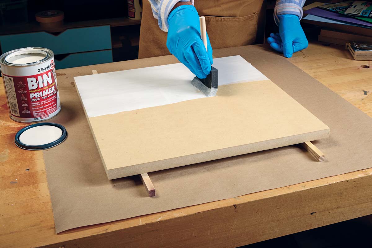using sponge brush to apply white primer to mdf board