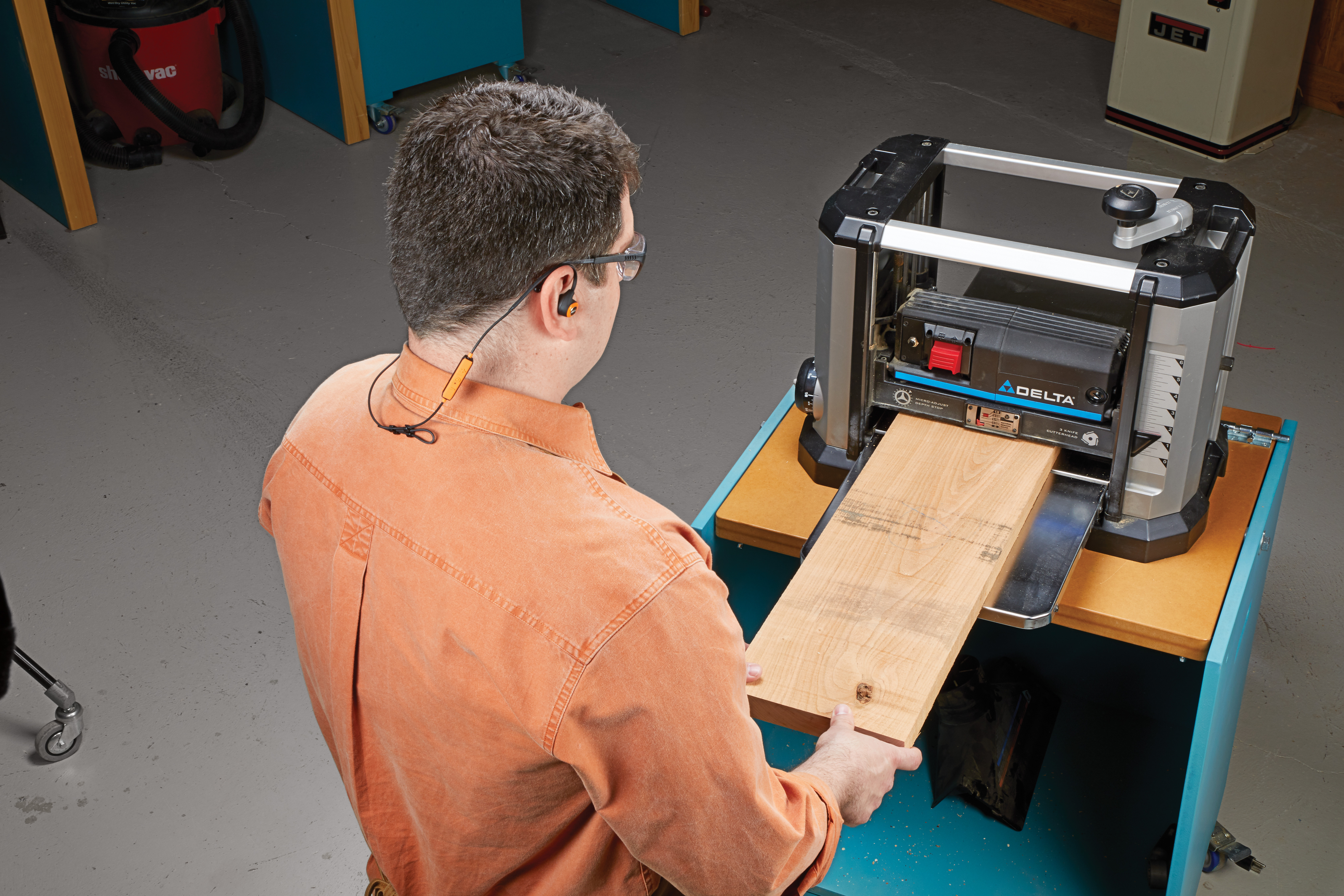 Man wears saftey glasses while using planer