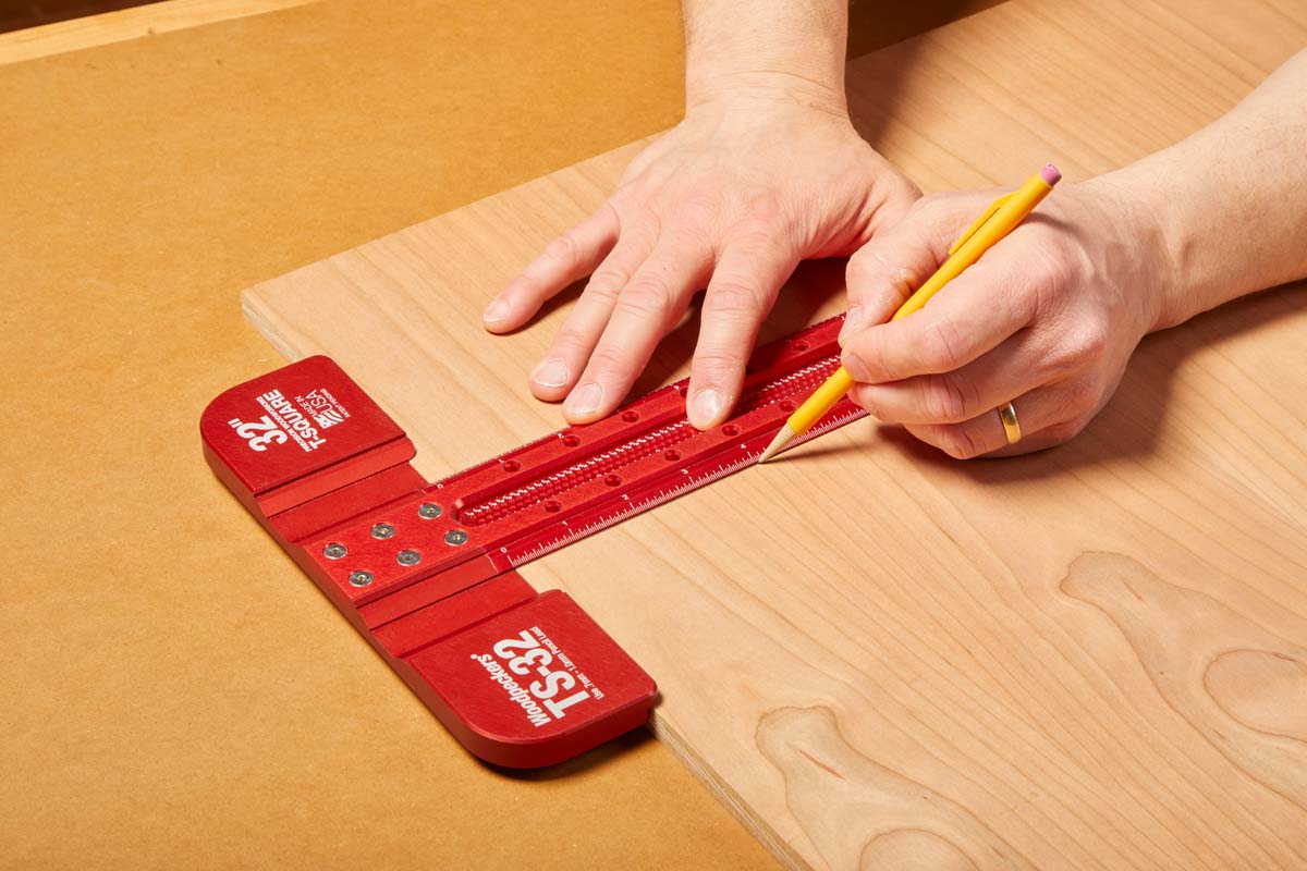 using red metal t square to mark on plywood