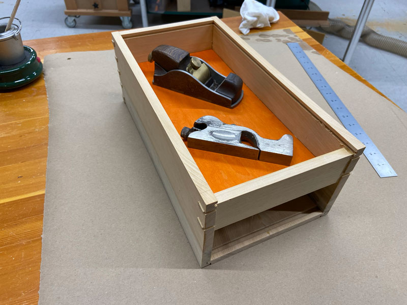 A tool box with two hand planes in the top section