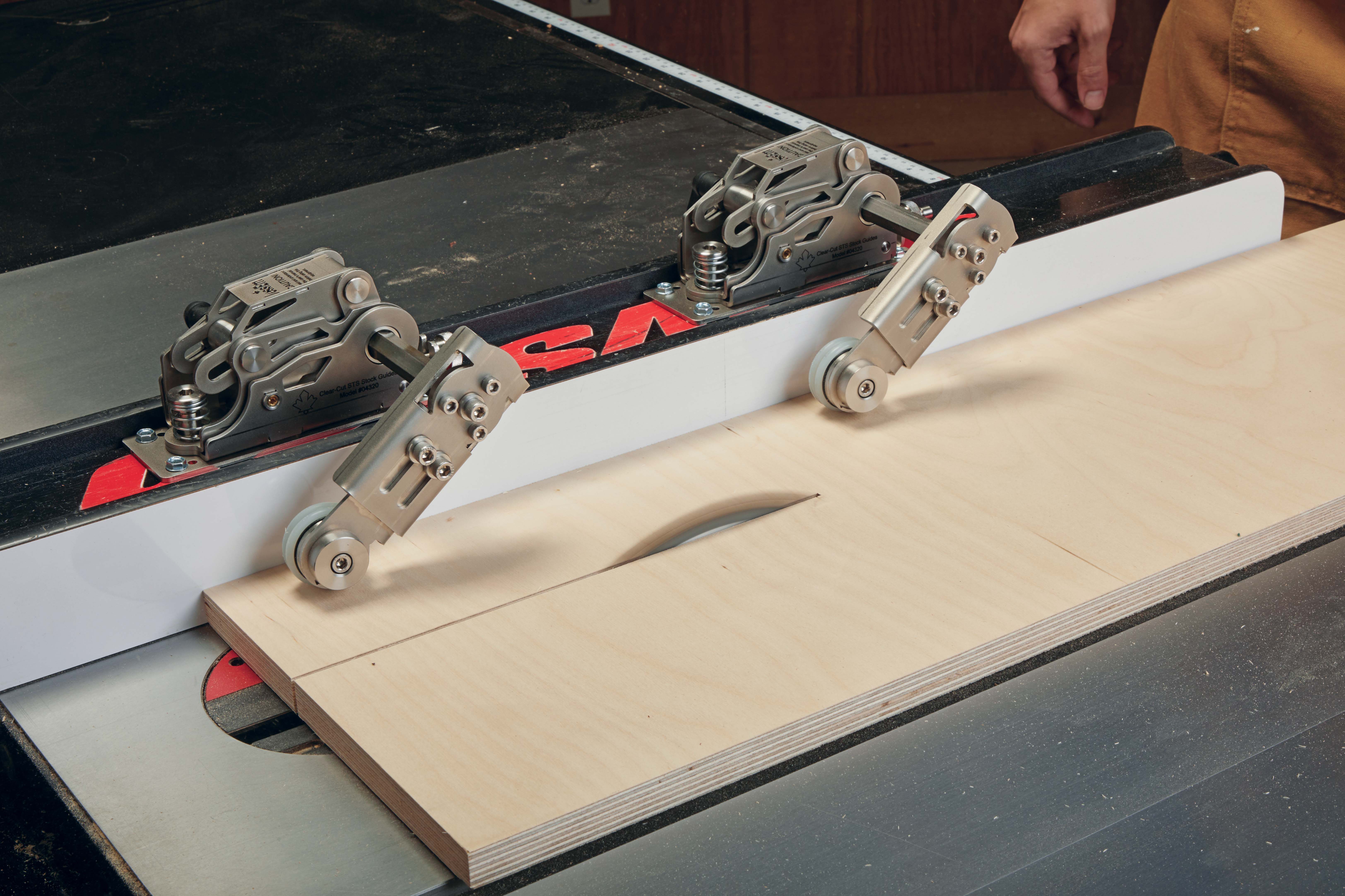 Arms of the STS Stock Guide hold stock piece down while bearings on the guide's rollers prevent kickback