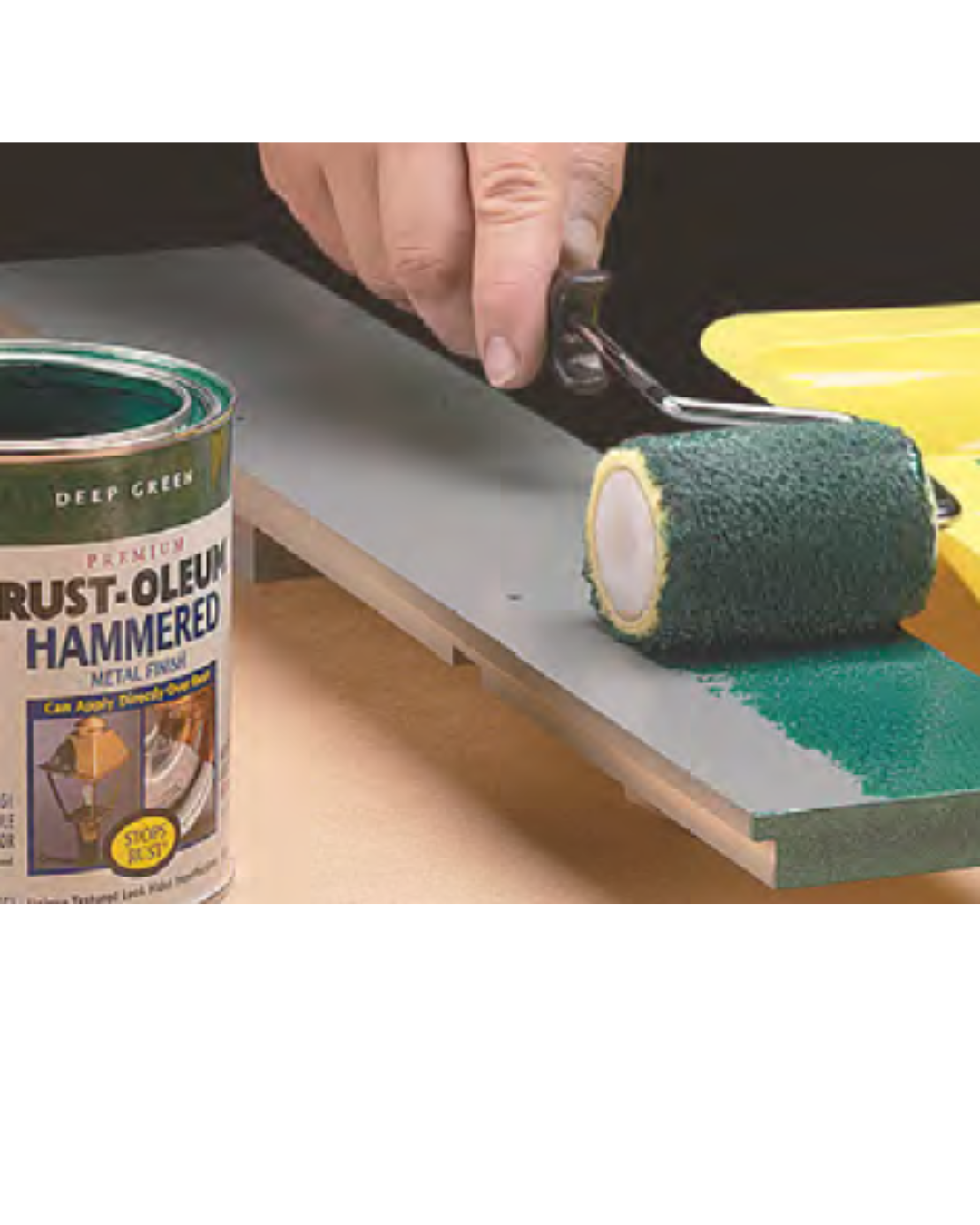 roller brush being used to spread green paint