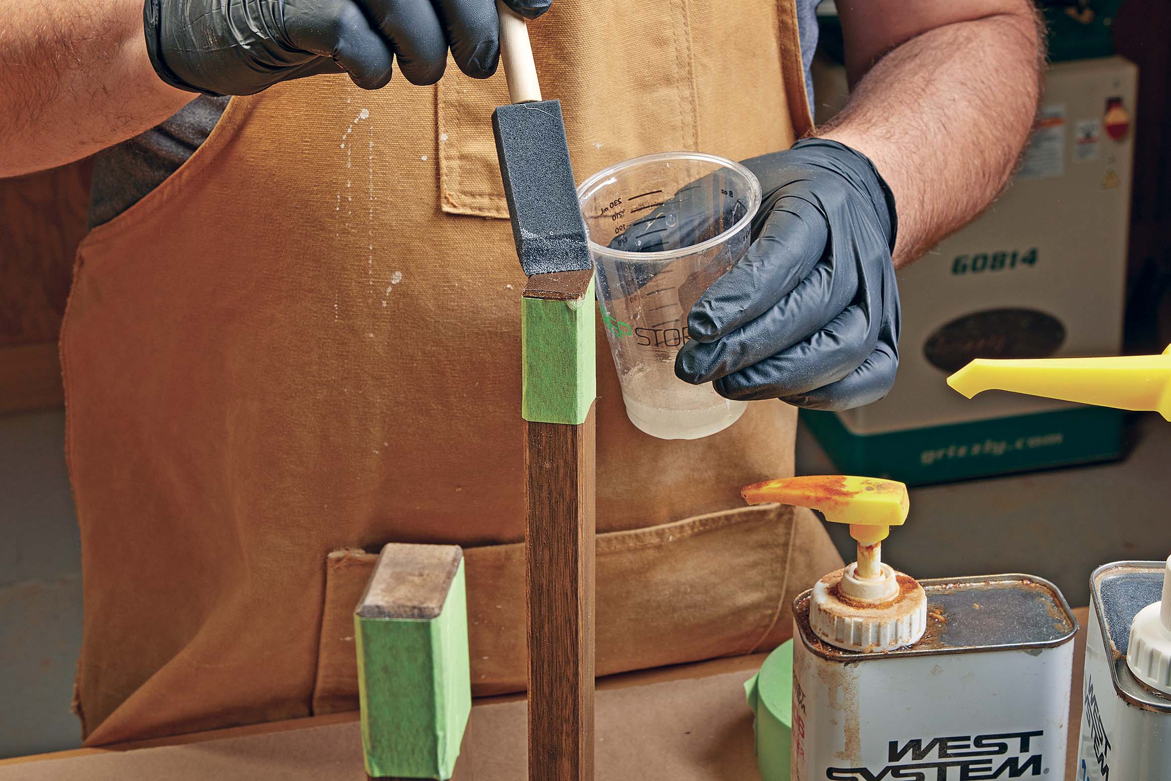 Using sponge to add epoxy resin to wood chair feet ends/bottoms