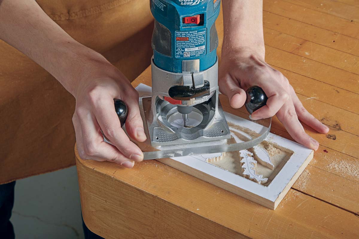 using hand-held palm router to clean out background for relief carving