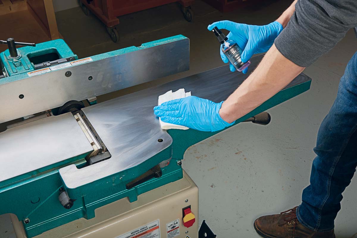 wearing blue latex gloves and wiping down surface wiht carbon cleanse solvent