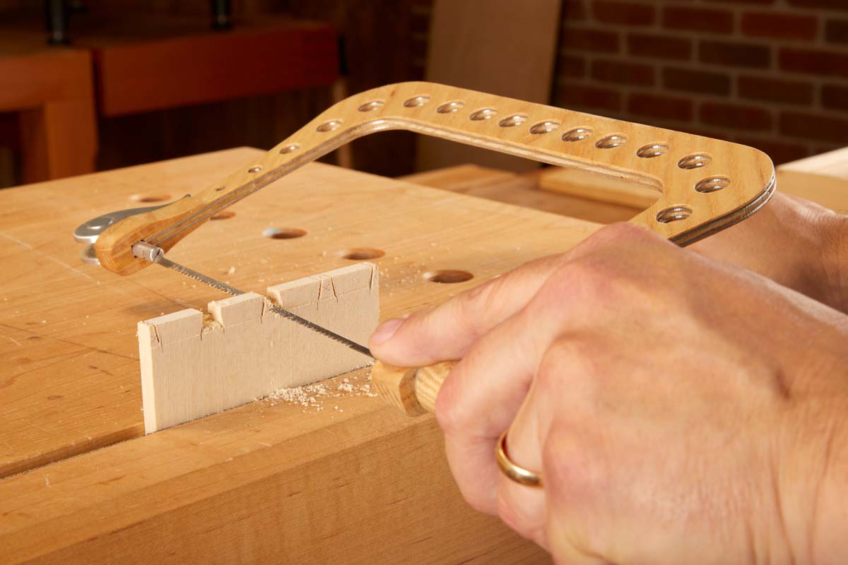 using coping saw to cut waste of dovetails horizontally