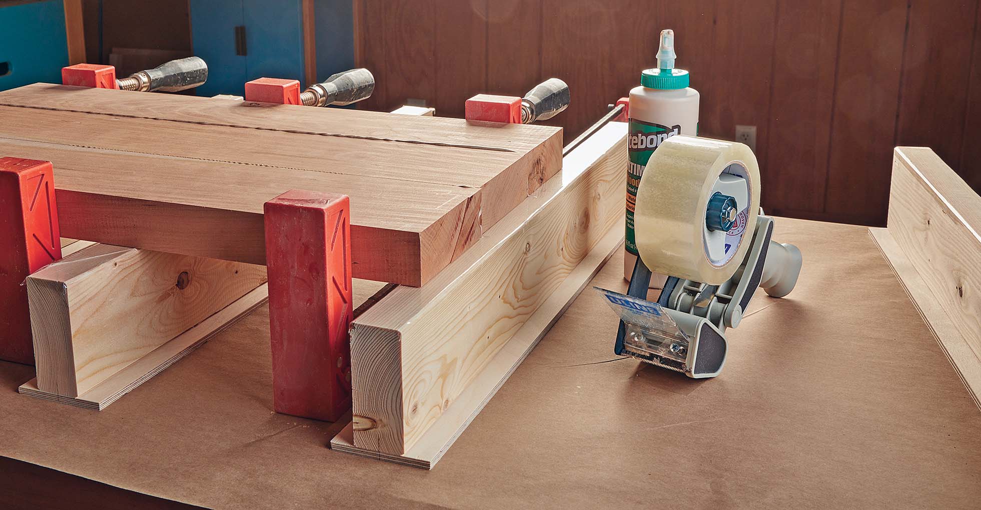Using packing tape to protect wood risers while drying glued board