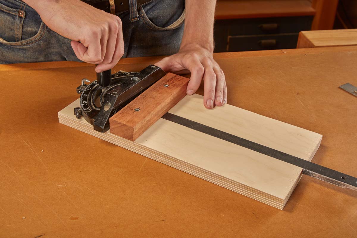 slotting the bar of the stock miter gauge into the groove and aligning the fence to the cleat