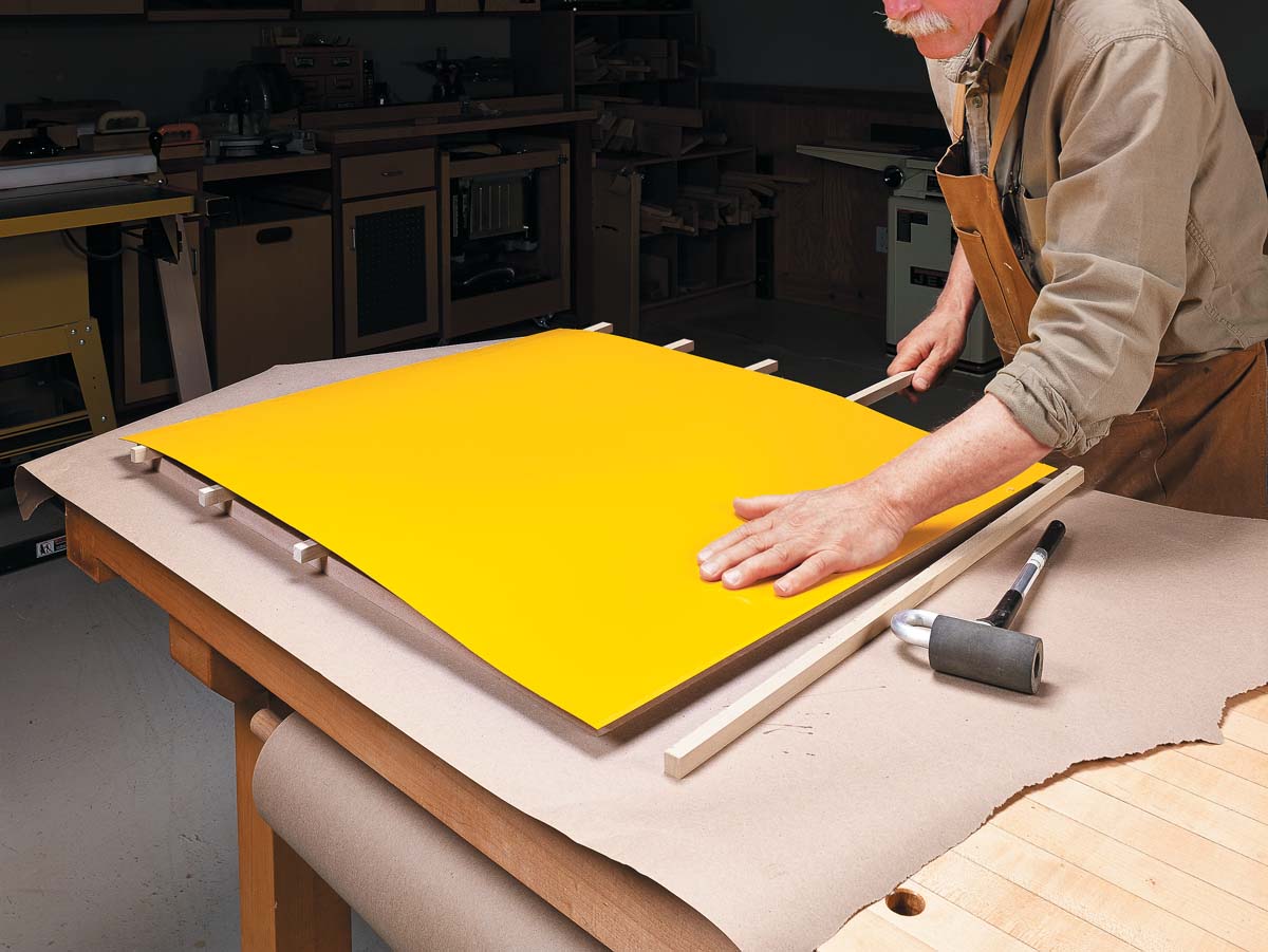 applying the yellow laminate by pressing down with your hand and removing each strip