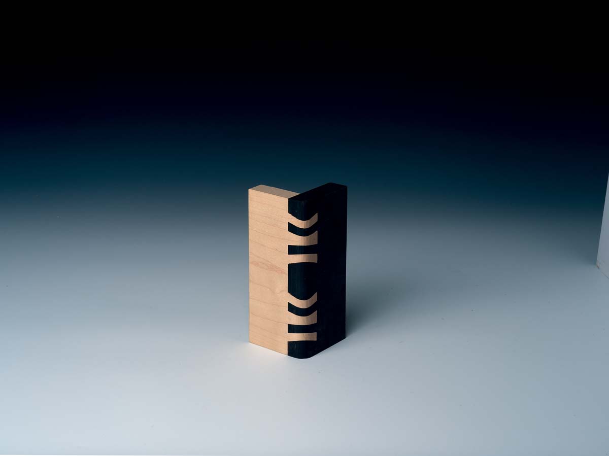 joinery example of double sunrise dovetail with one piece of wood painted black