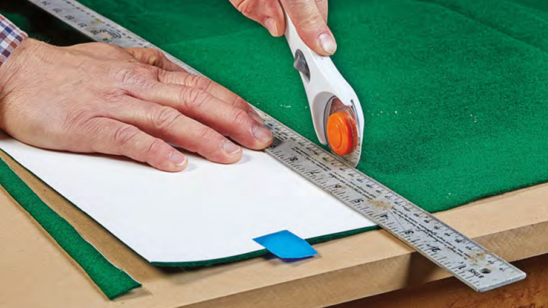 using long metal ruler as straight edge to cut fabric