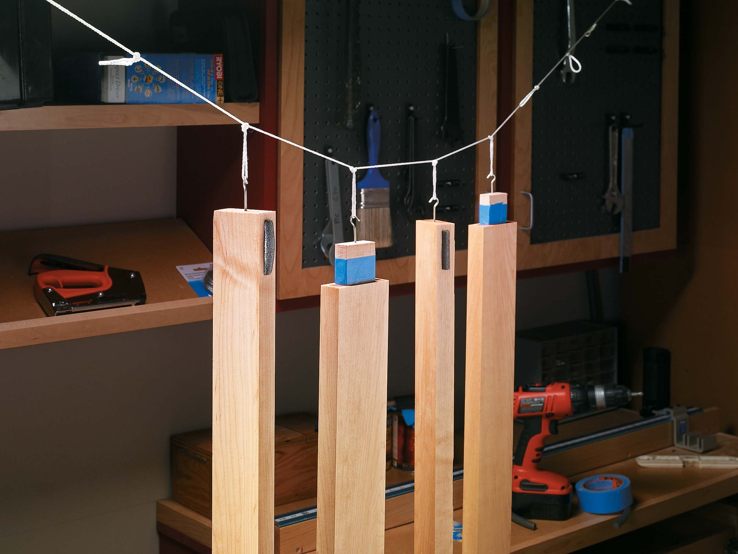 Wooden parts hanging from nylon line to help the wood finish dry even