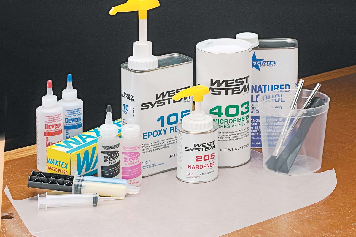 various epoxy resin products along with cups, brushes, and syringes