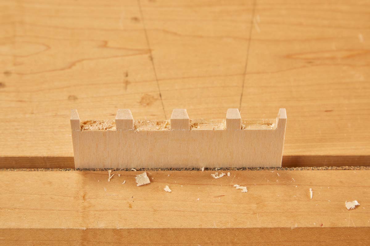 wood end with cut out dovetails, left end slightly crushed and messy compared to right end