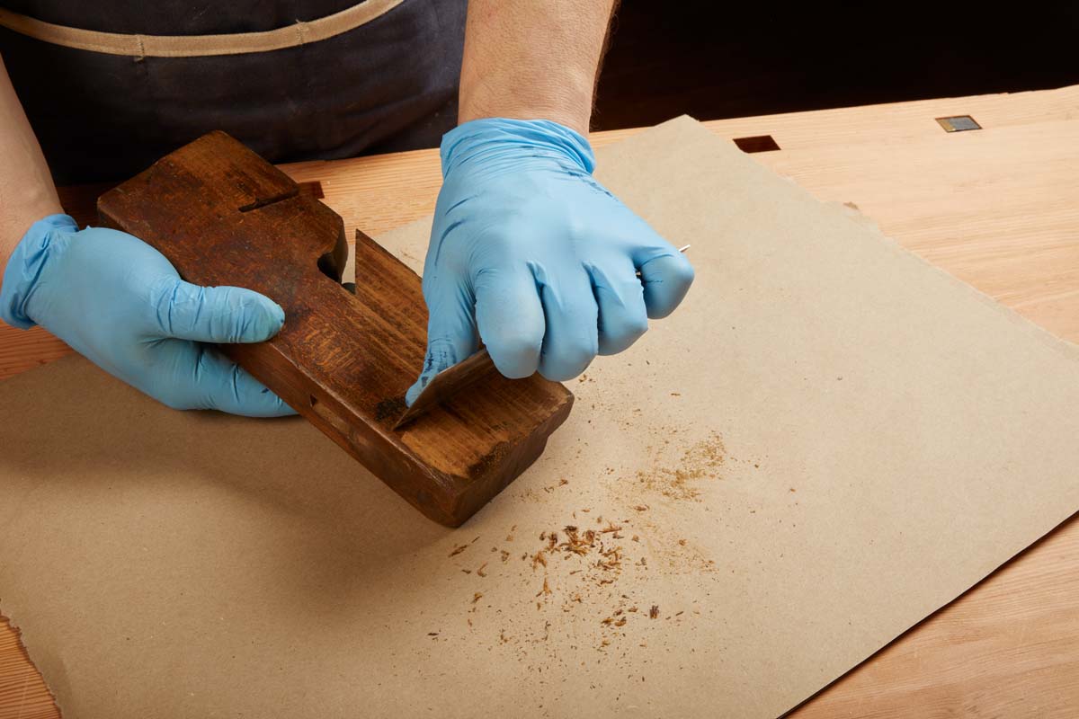 scraping off old wood from dado plane