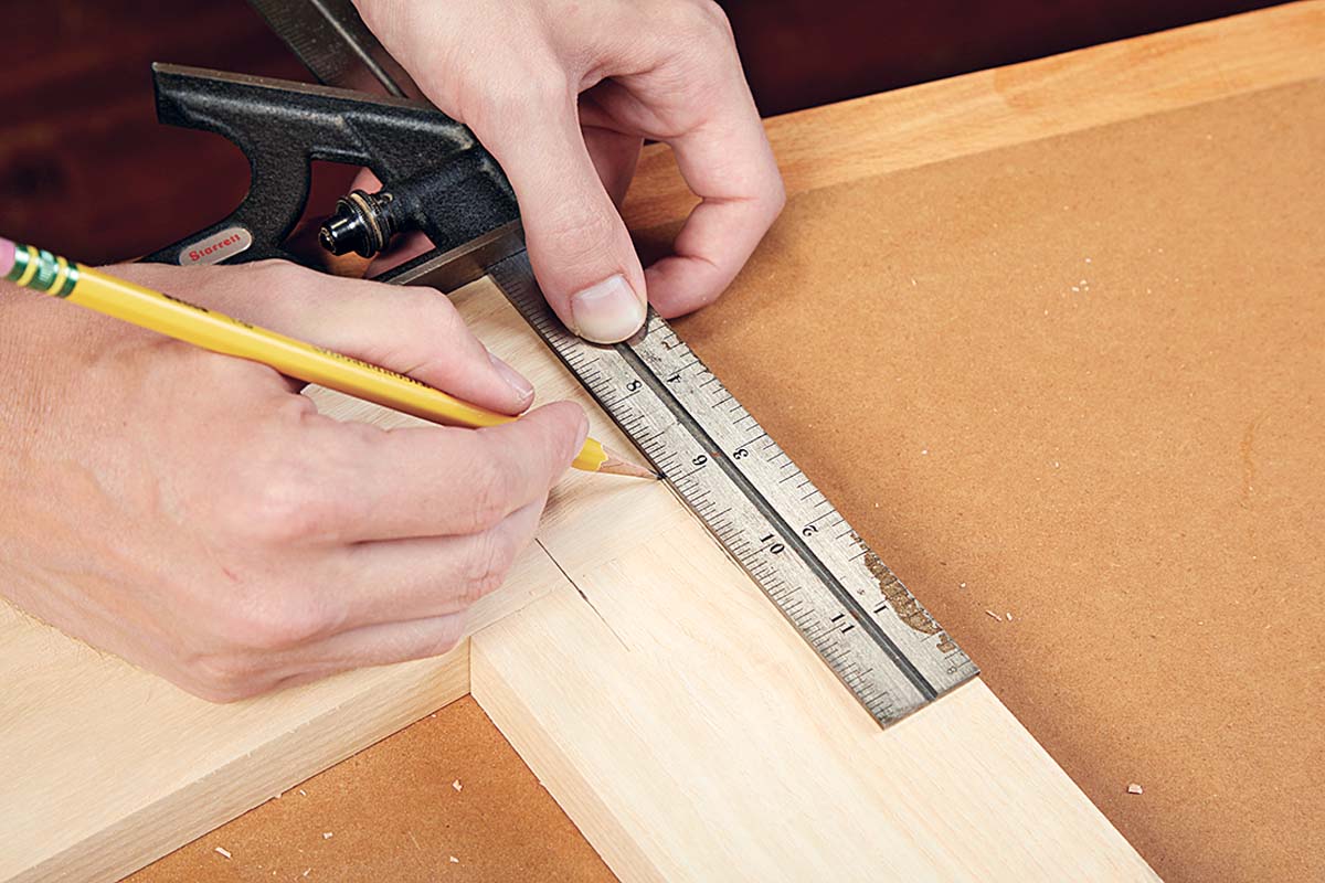 using ruler and pencil to mark spots on wood to add dowels