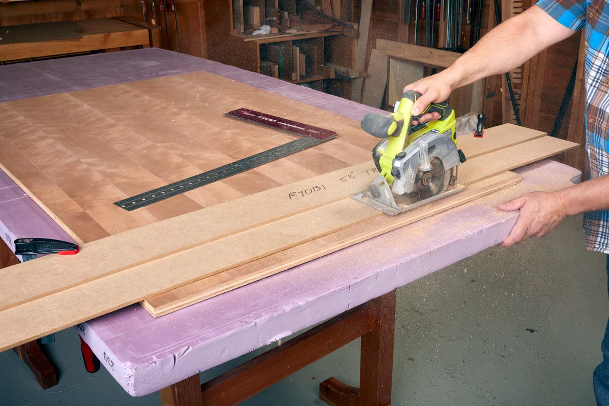 small yellow circular saw cutting plywood on purple foam insulation board