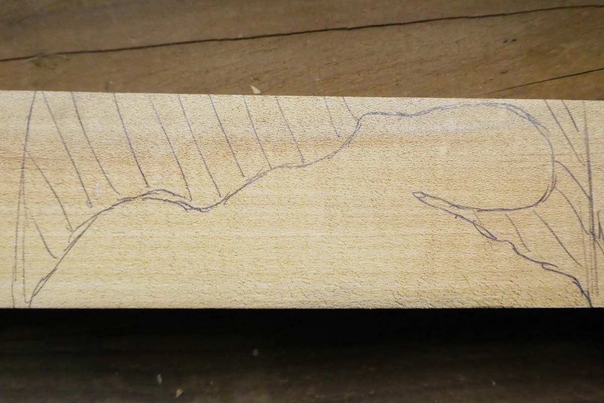 pencil marks on wood block for outline of octopus and lines showing where to carve