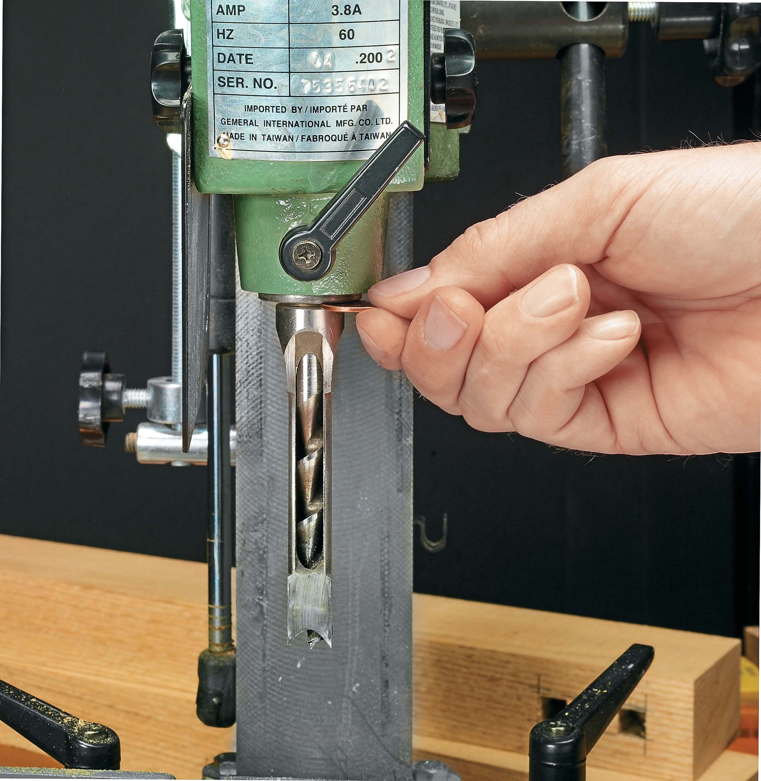 Using a peny to set the clearance between the end of the chisel and the bit