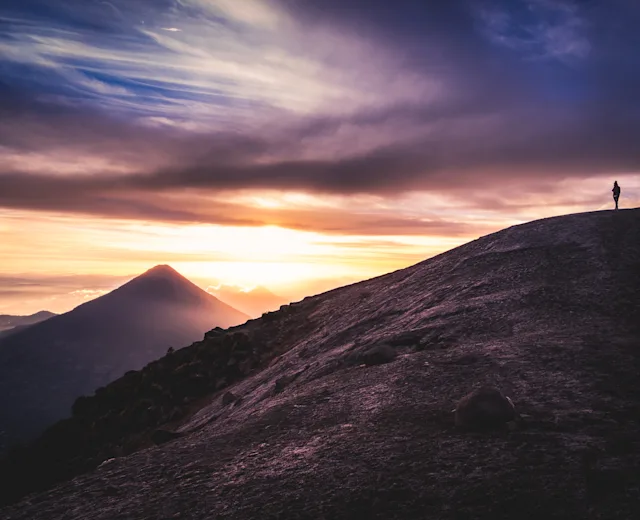 Hikers on a volcanic ridge at sunset