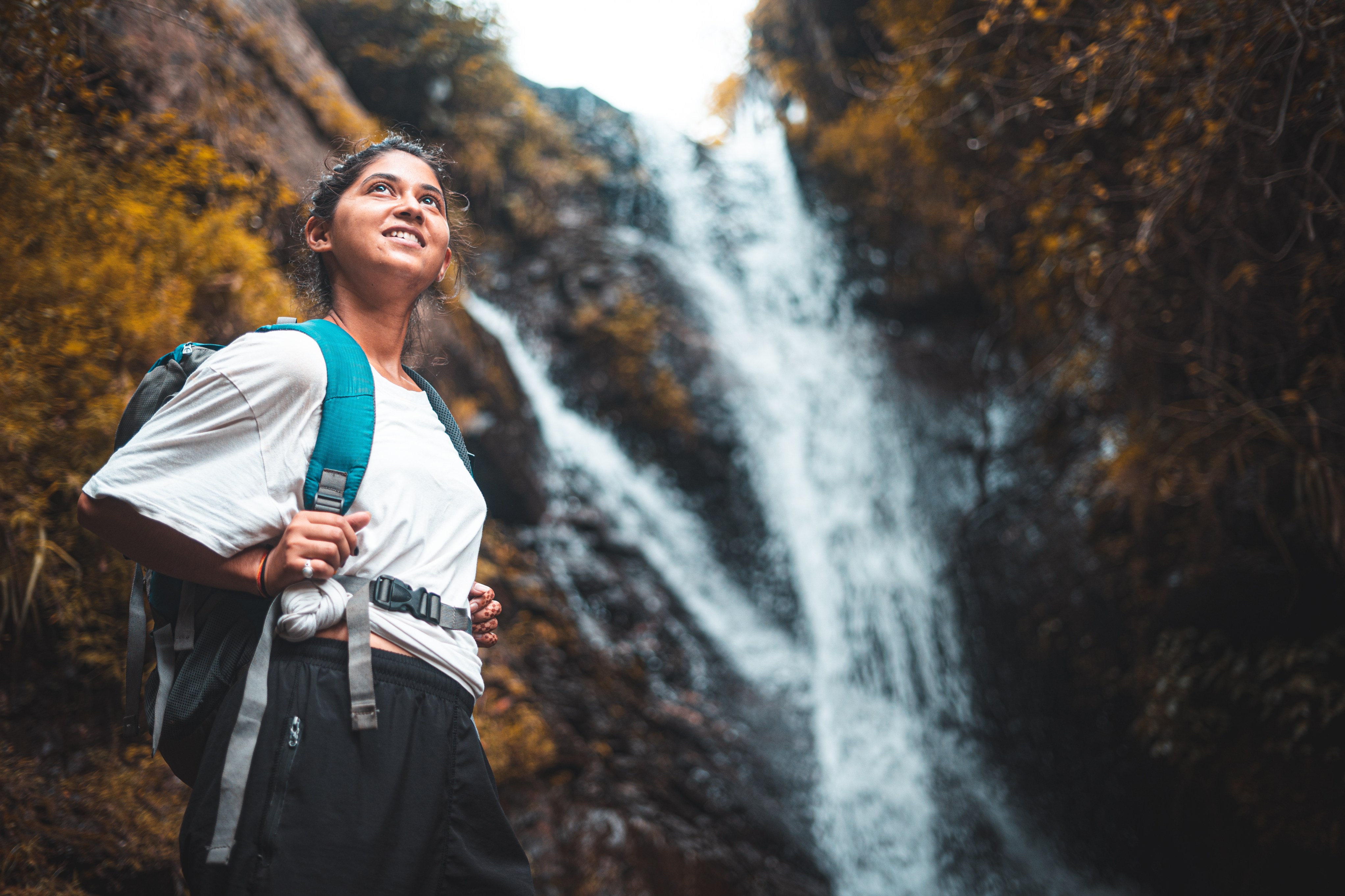 Hiker passing a forest waterfall, India.  Photo: GettyImages-1273427592