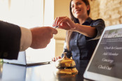Customer takes room key card at hotel check-in desk