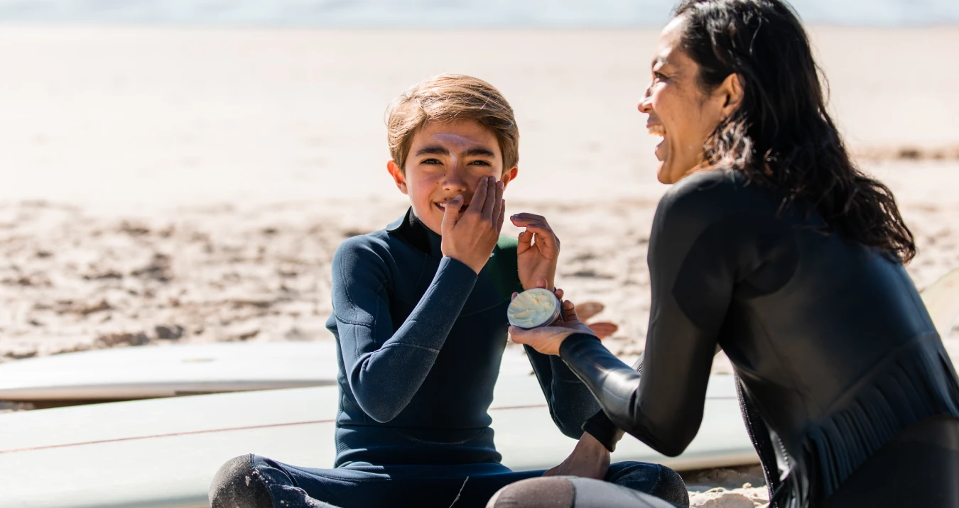 Boy applying sunscreen on face