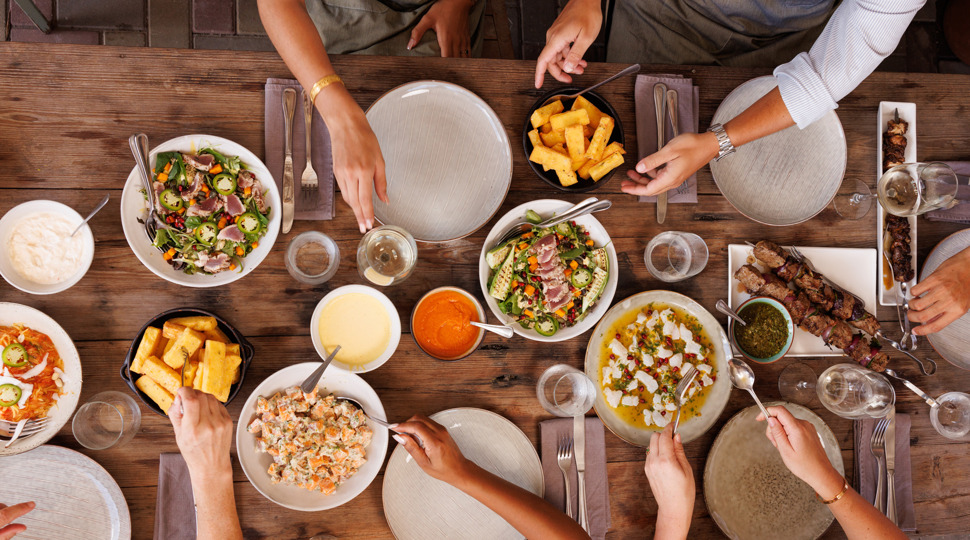 Food on table with hands