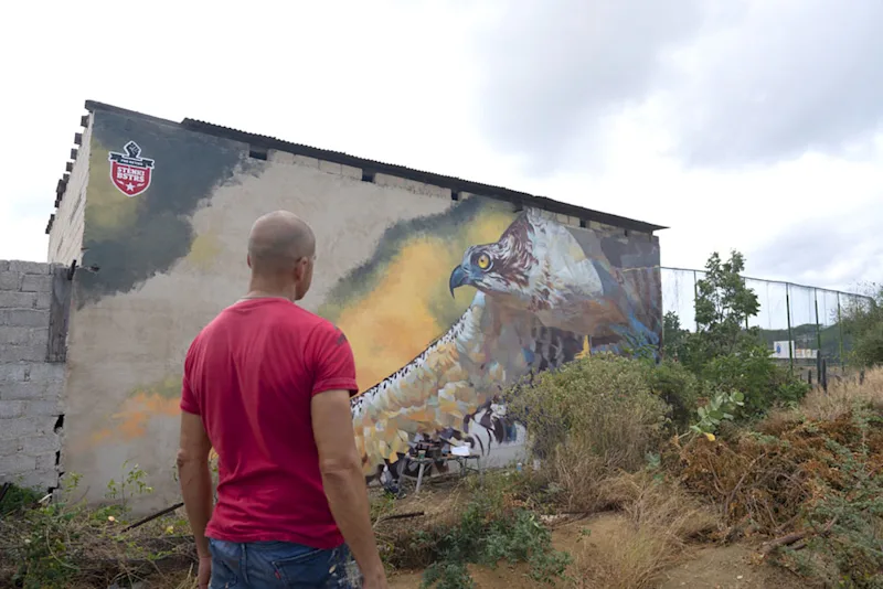 Garrick surveying his mural of an eagle.