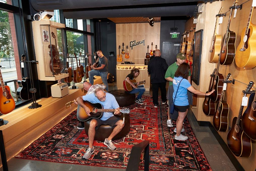 Music fans play in the Acoustic area of the Gibson Garage.