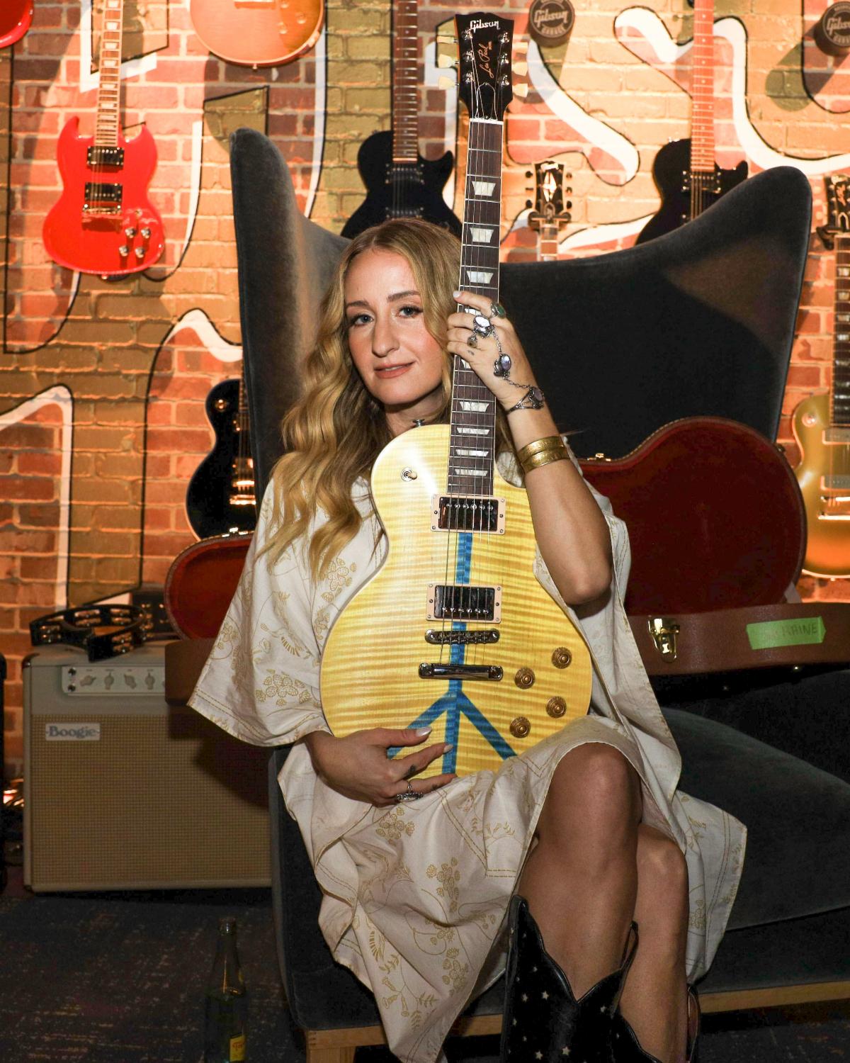 Margo Price is pictured with a Gibson Gives Guitars For Peace Les Paul.