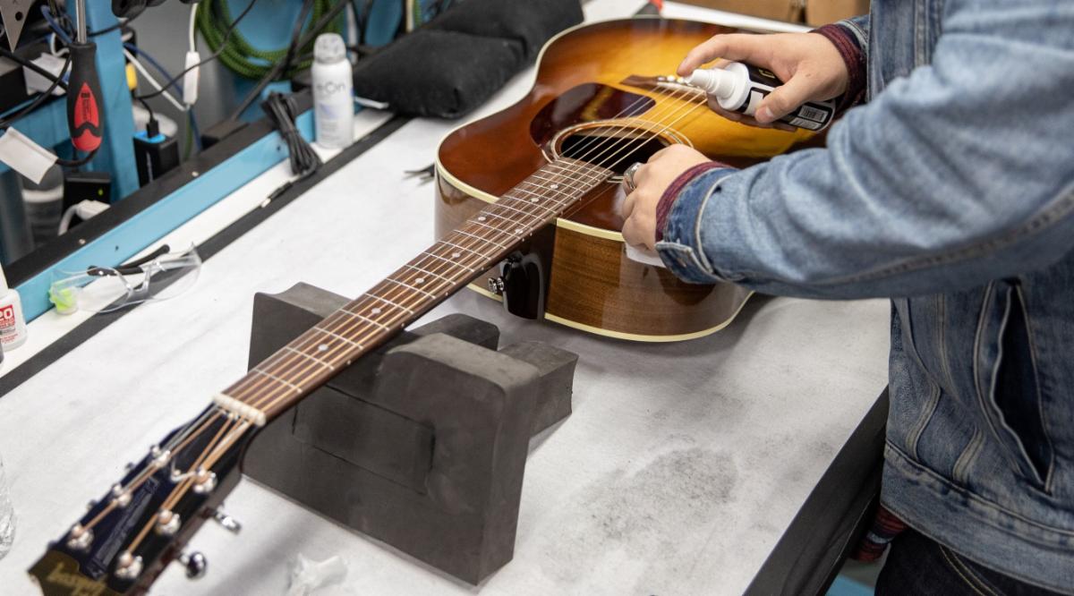 A Gibson R&R Tech restores a vintage Gibson J-45 acoustic guitar.