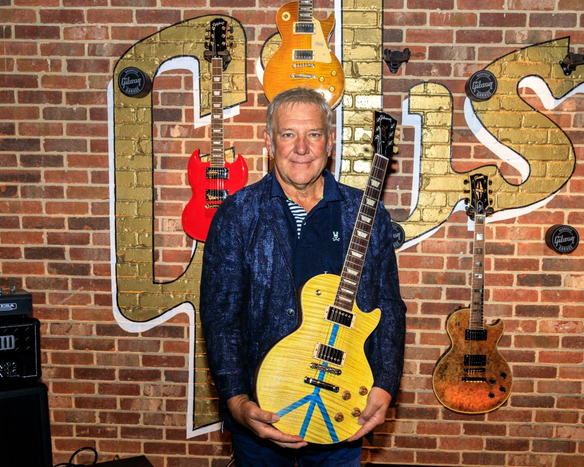 Alex Lifeson of RUSH is pictured with a Gibson Guitars For Peace Les Paul.