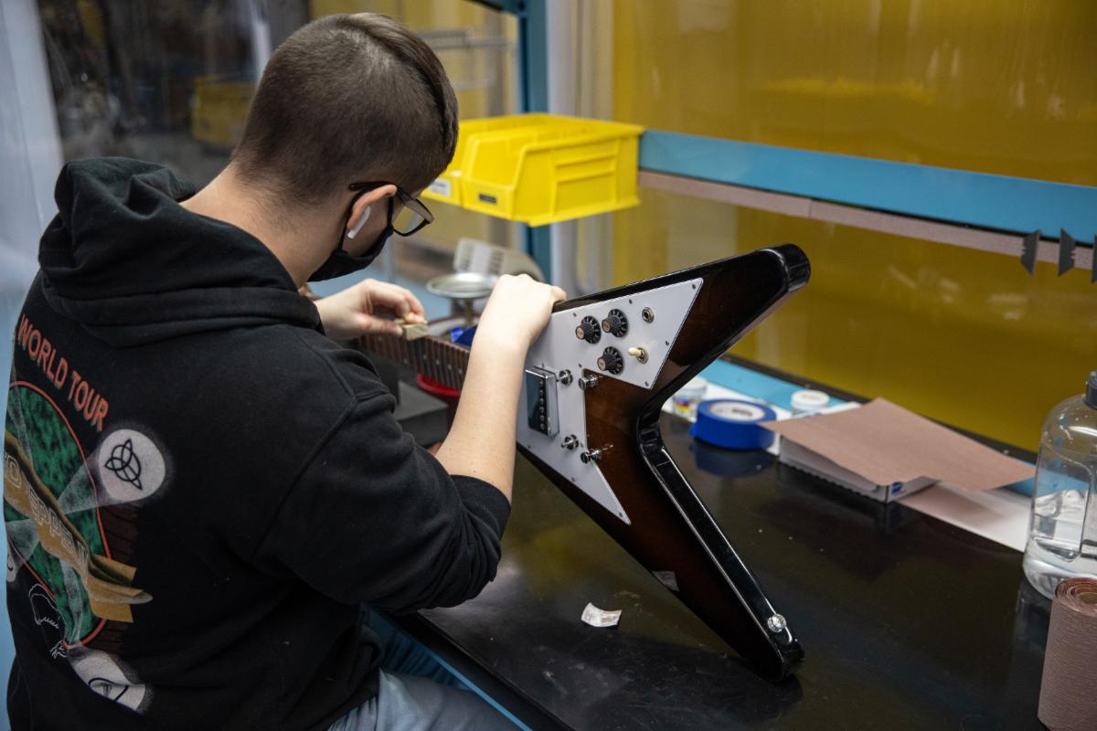 A Gibson R&R Tech repairs a Gibson Flying V.