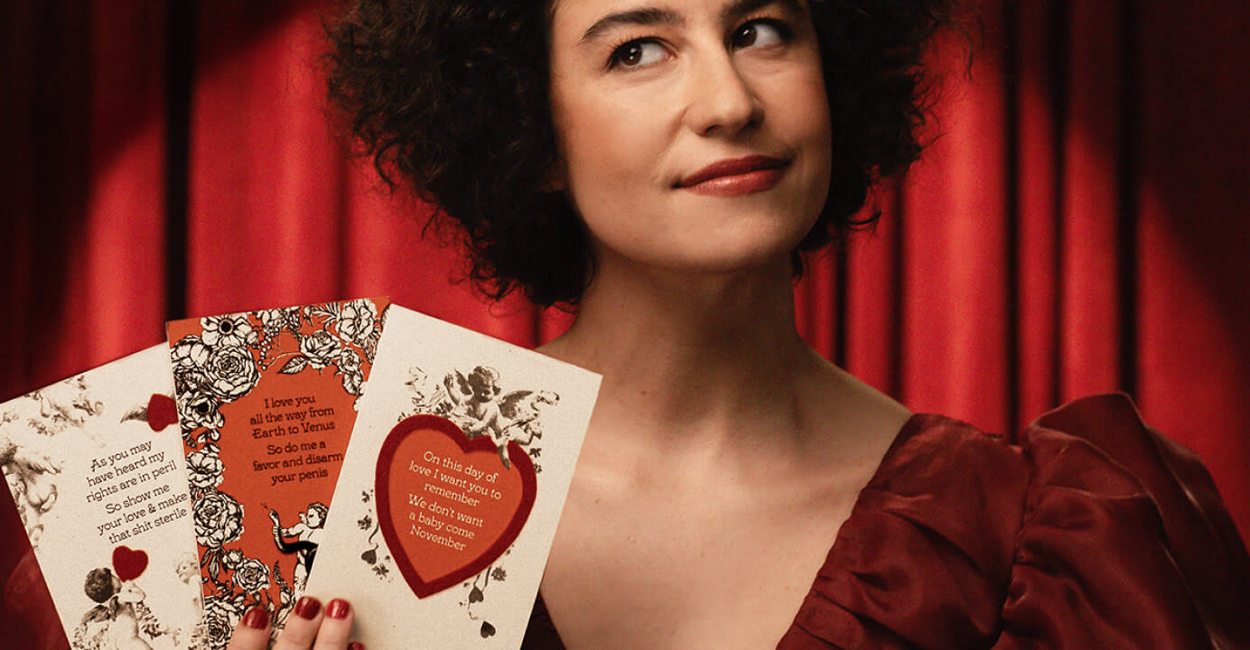 Ilana Glazer holding a Cards to Nards card