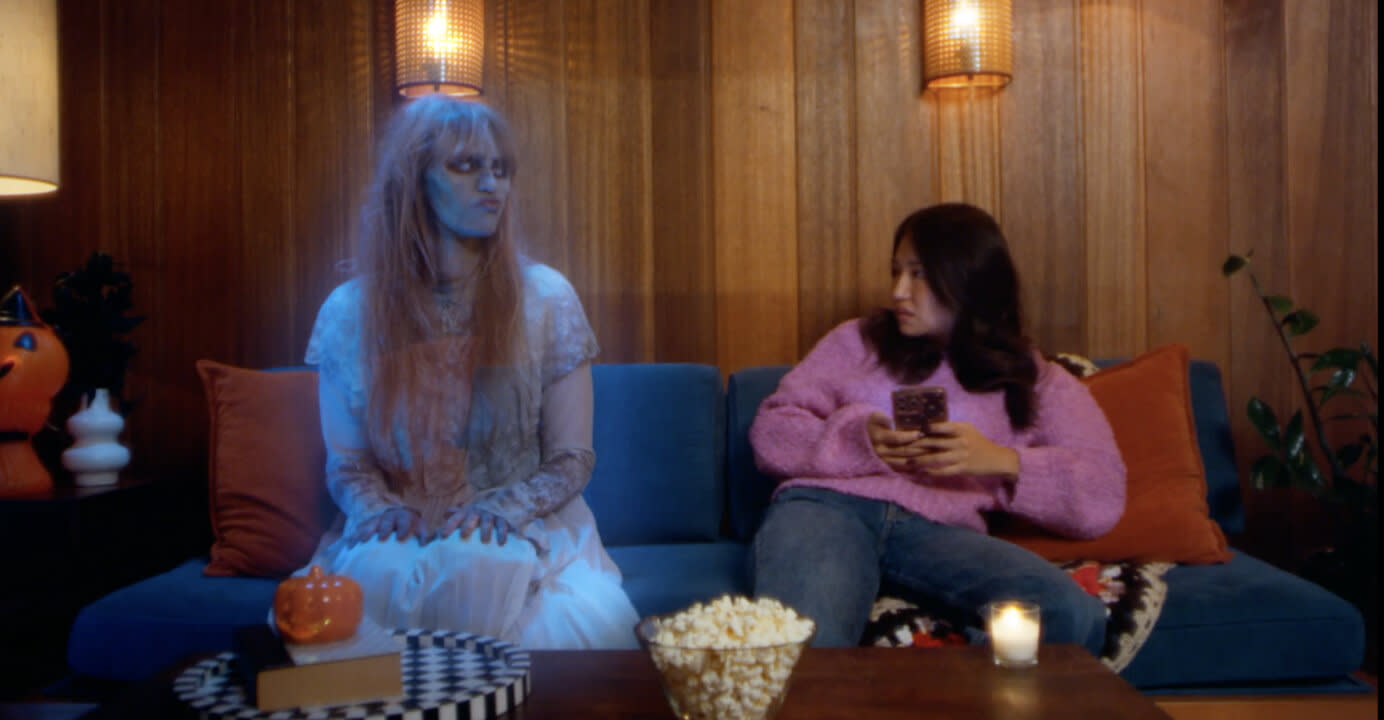 A ghostly woman and a woman have a chat on the couch about people who ghosted them 