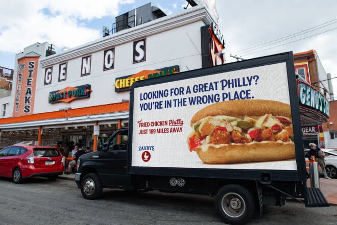 A truck parked outside of Geno's in Philly with a tag line of, "Looking for a great Philly? You're in the wrong place"